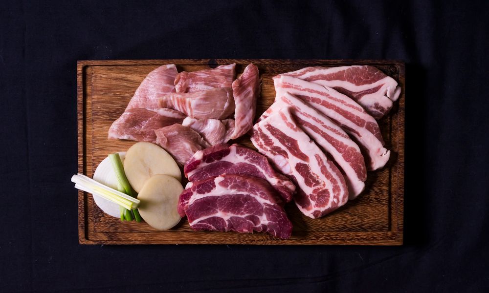 Cortes de carne cruda sobre tabla de madera